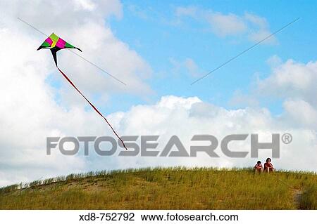Kite flying in the sky over a hill with two persons, Somo, Cantabria, Spain View Large Photo Image Stock Image - Kite flying in the sky over a hill with two persons, Somo, Cantabria, Spain. Fotosearch