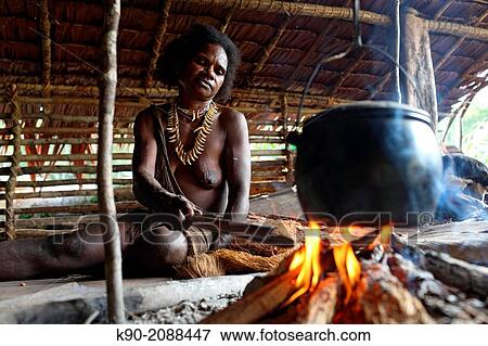 Kombai woman sitting with necklace made of dog teeth at the fire place and cooking, Papua, Indonesia, Southeast Asia. View Large Photo Image Stock Photo - Kombai woman sitting with necklace made of dog teeth at the fire place and cooking, Papua, Indonesia, Southeast Asia.. Fotosearch