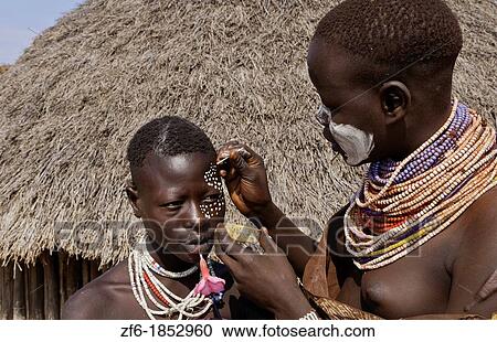 Stock Image - Korcho Ethiopia Africa village Lower Omo Valley Karo tribe putting on painted face 25. Fotosearch