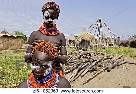 Korcho Ethiopia Africa village Lower Omo Valley Karo tribe with painted faces fixing red hair curls 25 View Large Photo Image Stock Photo - Korcho Ethiopia Africa village Lower Omo Valley Karo tribe with painted faces fixing red hair curls 25. Fotosearch