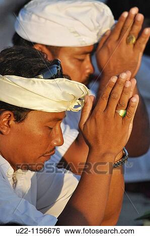 Kuta Beach (Bali, Indonesia): man at a collective pray during a Hindu ritual on the beach View Large Photo Image Stock Photograph - Kuta Beach (Bali, Indonesia): man at a collective pray during a Hindu ritual on the beach. Fotosearch