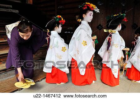 Stock Image - Kyoto (Japan): very young Maiko (apprentice geishas) during a ceremony at the Kitano Tenmangu shrine. Fotosearch