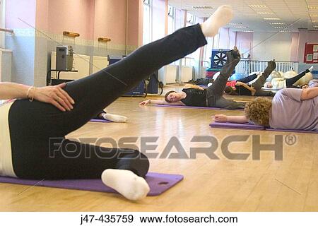 Ladies lying on floor in a pilates class, exercising View Large Photo Image Stock Photo - Ladies lying on floor in a pilates class, exercising. Fotosearch