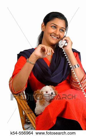 Lady expressing herself while engaged in a telephonic conversation. View Large Photo Image Picture - Lady expressing herself while engaged in a telephonic conversation.. Fotosearch