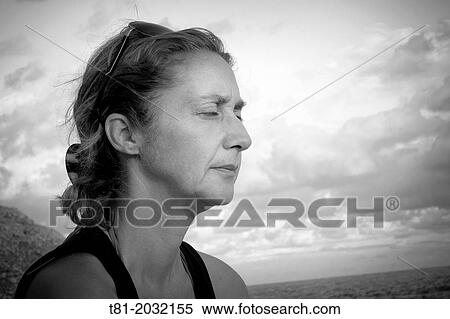 Stock Photography - Lady meditating on the beach of Alcossebre, Castellon, Spain. Fotosearch