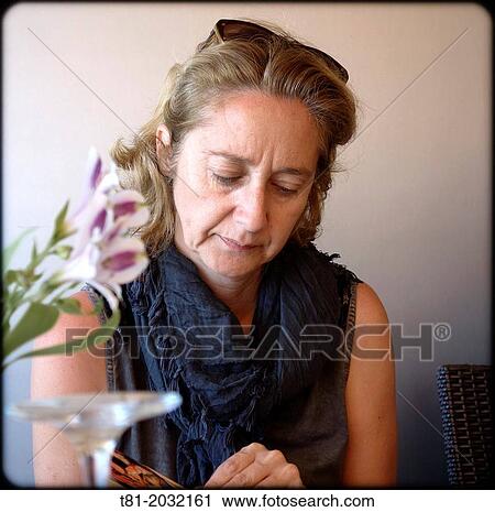 Stock Image - Lady reading in Denia, Spain. Fotosearch