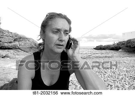 . Lady softened by phone on the beach alcocebre, Castellon, Spain View Large Photo Image Stock Photograph - . Lady softened by phone on the beach alcocebre, Castellon, Spain. Fotosearch
