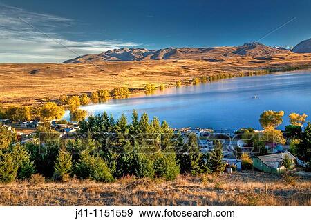 Stock Photo - Lake Alexandrina Wildlife Refuge and fishing baches at dawn, popular spot for trout fishermen and their row boats -no engines allowed on lake-, autumn, near Lake Tekapo, Mackenzie country, Canterbury. Fotosearch