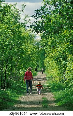 Lake Orion, Michigan - Susan Newell and her daughter, Mariel West, 18 months, walk on the Paint Creek Trail, a former railroad that has been converted to a trail for walking and bicycling and for cross country skiing in winter MR View Large Photo Image Picture - Lake Orion, Michigan - Susan Newell and her daughter, Mariel West, 18 months, walk on the Paint Creek Trail, a former railroad that has been converted to a trail for walking and bicycling and for cross country skiing in winter MR. Fotosearch