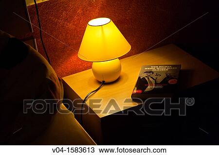 Lamp and a book on a bedside table View Large Photo Image Stock Image - Lamp and a book on a bedside table. Fotosearch