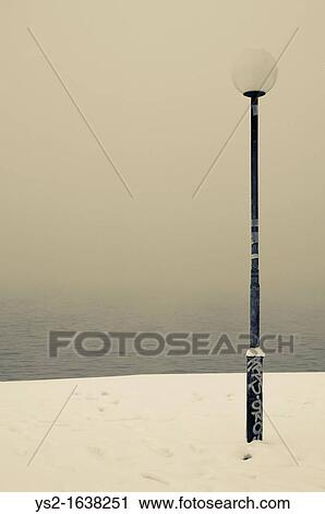 Stock Image - Lamp Post and a foggy lake. Fotosearch