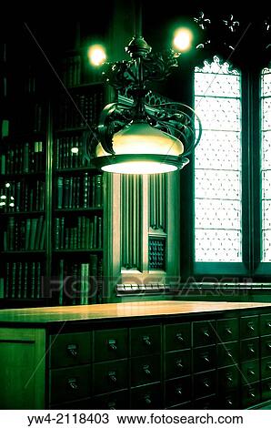 Stock Image - Lamp shining over filing cabinet.. Fotosearch