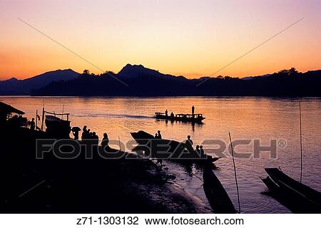 Laos, Luang Prabang, Mekong river, boats, people, sunset, View Large Photo Image Stock Image - Laos, Luang Prabang, Mekong river, boats, people, sunset,. Fotosearch