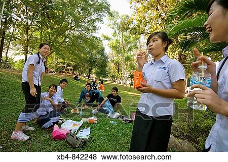 Stock Photo - Laos, Vientiane, group of students relaxing in one of the park in the town centre.. Fotosearch