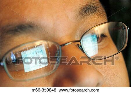 Laptop screen reflecting in an Asian-American man's glasses as he surfs the Internet View Large Photo Image Stock Photo - Laptop screen reflecting in an Asian-American man's glasses as he surfs the Internet. Fotosearch