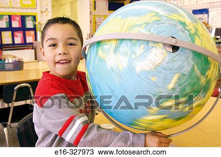 Stock Image - Latin boy spinning the globe. Fotosearch