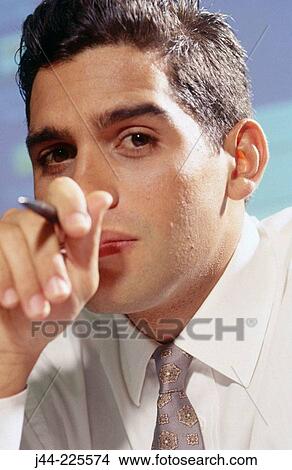 Latin businessman holding a pen View Large Photo Image Picture - Latin businessman holding a pen. Fotosearch