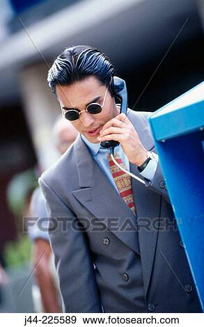 Latin businessman on public phone in the street View Large Photo Image Stock Photo - Latin businessman on public phone in the street. Fotosearch