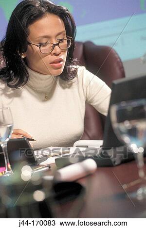 Latin businesswoman working with laptop on desk View Large Photo Image Stock Image - Latin businesswoman working with laptop on desk. Fotosearch