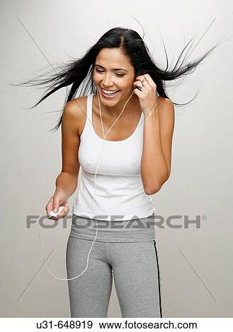 Stock Photo - Latin girl listening and enjoying music. Fotosearch