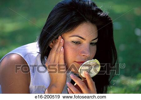 Latin lady looking in hand mirror View Large Photo Image Stock Photo - Latin lady looking in hand mirror. Fotosearch