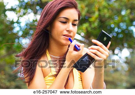 Stock Photo - Latin lady putting on makeup. Fotosearch