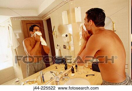 Latin man drying up his face with hand towel in a hotel bathroom View Large Photo Image Stock Image - Latin man drying up his face with hand towel in a hotel bathroom. Fotosearch