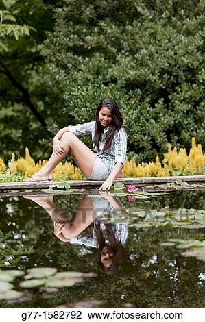 Stock Image - Latin woman in a park.. Fotosearch