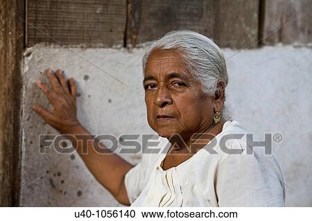Stock Image - Latin woman in front of home. Fotosearch