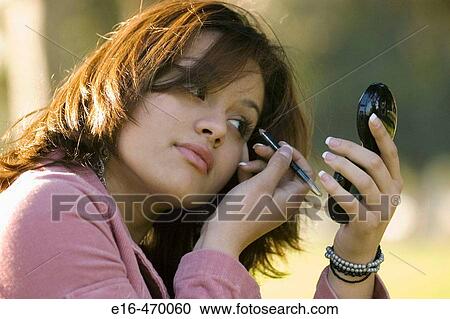 Latin woman putting on makeup View Large Photo Image Stock Image - Latin woman putting on makeup. Fotosearch