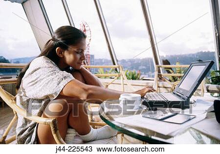 Latin woman working with laptop computer and cup of coffee in the house terrace View Large Photo Image Stock Image - Latin woman working with laptop computer and cup of coffee in the house terrace. Fotosearch