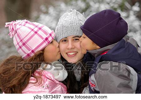 Latino sister and brother kissing big sister View Large Photo Image Stock Photo - Latino sister and brother kissing big sister. Fotosearch