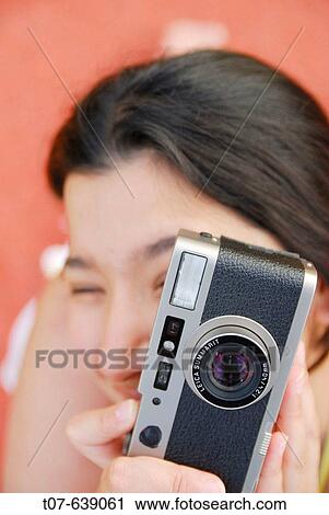 Stock Image - Latino Woman holding a camera.. Fotosearch