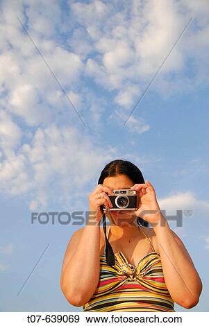 Stock Photo - Latino Woman holding a camera.. Fotosearch