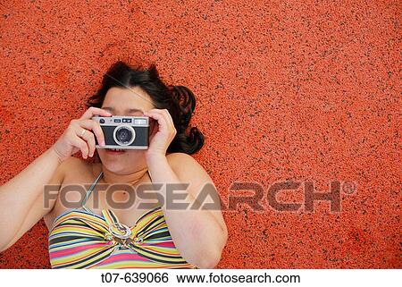 Latino Woman holding a camera. View Large Photo Image Stock Photograph - Latino Woman holding a camera.. Fotosearch