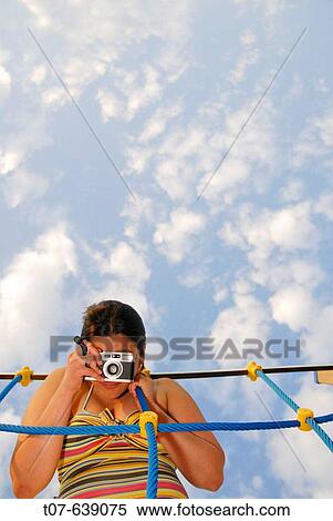 Stock Photography - Latino woman holding a camera.. Fotosearch