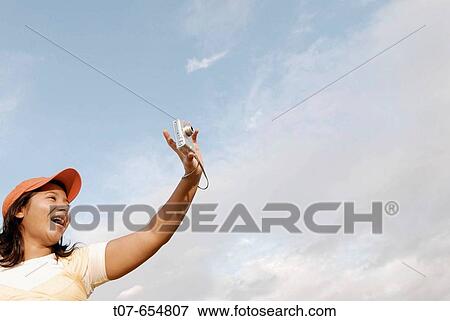 Latino woman holding digital camera. View Large Photo Image Stock Photo - Latino woman holding digital camera.. Fotosearch