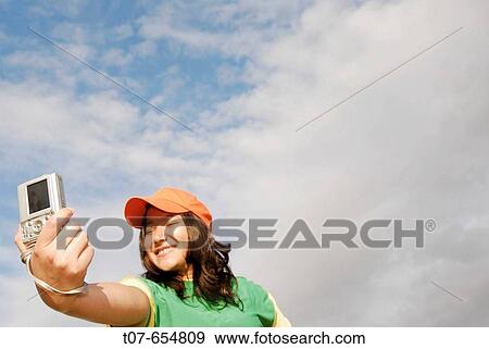 Latino woman holding digital camera. View Large Photo Image Stock Photo - Latino woman holding digital camera.. Fotosearch