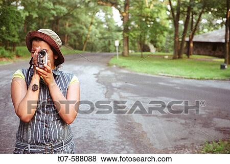 Latino woman holding video camera. View Large Photo Image Stock Photo - Latino woman holding video camera.. Fotosearch