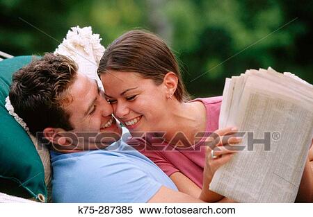 Stock Photography - Laughing and reading the newspaper together. Fotosearch