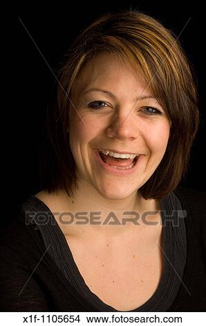 Laughing young woman against black background View Large Photo Image Picture - Laughing young woman against black background. Fotosearch