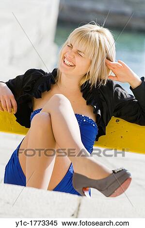 Stock Photography - Laughing young woman in Blue dress at mid-day time. Fotosearch