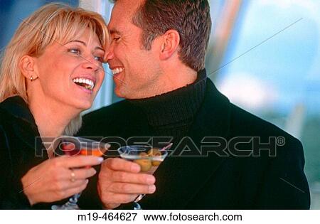 laughing/smiling couple enjoying a cocktail View Large Photo Image Stock Photo - laughing/smiling couple enjoying a cocktail. Fotosearch