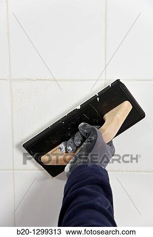 Laying tiles, glue mortar, using grout float, new homes under construction, construction site View Large Photo Image Stock Image - Laying tiles, glue mortar, using grout float, new homes under construction, construction site. Fotosearch