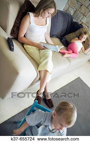 Lazy afternoon. 4 y/o daughter & 18 months toddler son relaxing with mother in livingroom. View Large Photo Image Picture - Lazy afternoon. 4 y/o daughter & 18 months toddler son relaxing with mother in livingroom.. Fotosearch