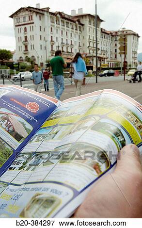 Leafing through a real property magazine. Hendaye. Aquitaine. France. View Large Photo Image Stock Photo - Leafing through a real property magazine. Hendaye. Aquitaine. France.. Fotosearch