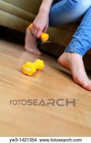 legs of a young caucasian woman in jeans with dumbbells in hand View Large Photo Image Picture - legs of a young caucasian woman in jeans with dumbbells in hand. Fotosearch