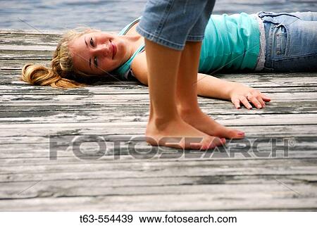 legs of girl 18 standing girl 13 laying on dock on lake View Large Photo Image Stock Photo - legs of girl 18 standing girl 13 laying on dock on lake. Fotosearch