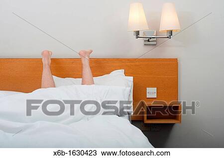 Legs pointing up from under bed covers View Large Photo Image Stock Image - Legs pointing up from under bed covers. Fotosearch