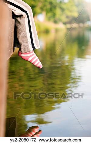 Lifestyle moment of summer childhood. Little girl sitting on jetty by canal. View Large Photo Image Stock Image - Lifestyle moment of summer childhood. Little girl sitting on jetty by canal.. Fotosearch